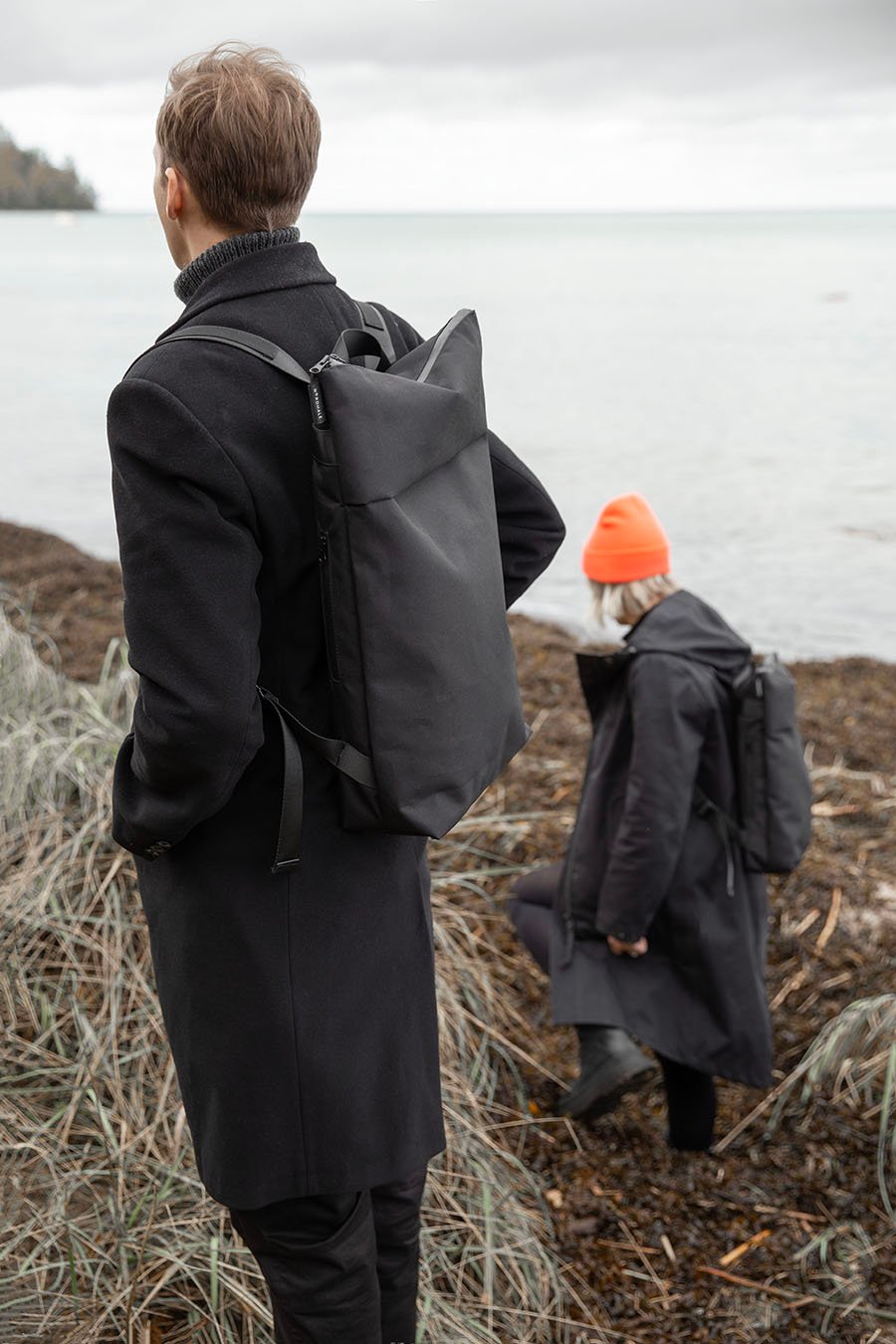 6. Unisex Nordhale HØLAR Weatherproof Backpack worn by male and female models in outdoor setting, showcasing durability