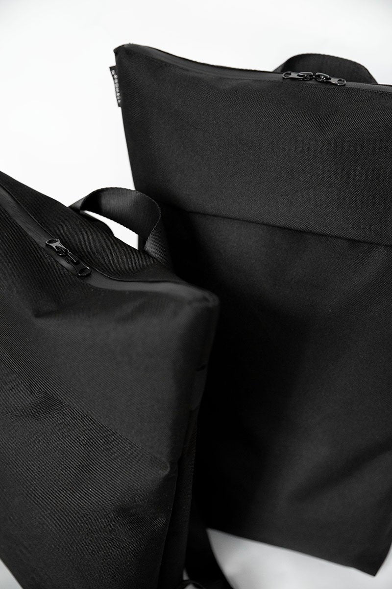 12. Studio shot of two Nordhale HØLAR Weatherproof Backpacks, showcasing size options and sleek design