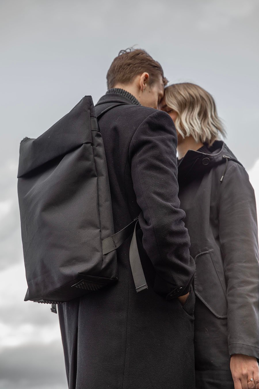 5. Unisex Nordhale HØLAR Weatherproof Backpack worn by male and female models, highlighting sleek design and comfort