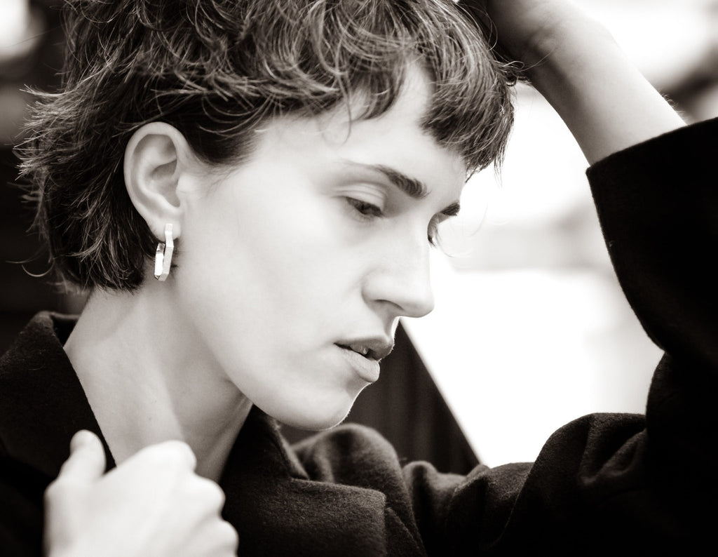 1. Woman wearing Lisa Kroeber Jewellery Hoops Silver Earrings, showcasing elegant design in lifestyle setting