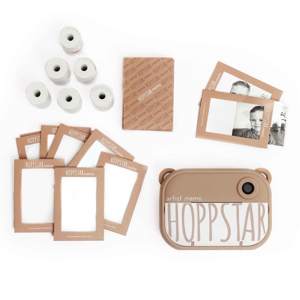 4. Flat lay of Hoppstar Artist Memo camera, memory game cards, and paper rolls