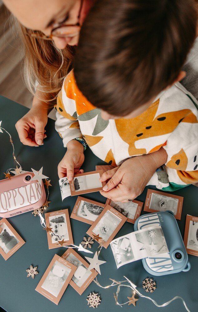1. Child and adult playing Hoppstar Memory Game with personalized photo cards on a decorated table