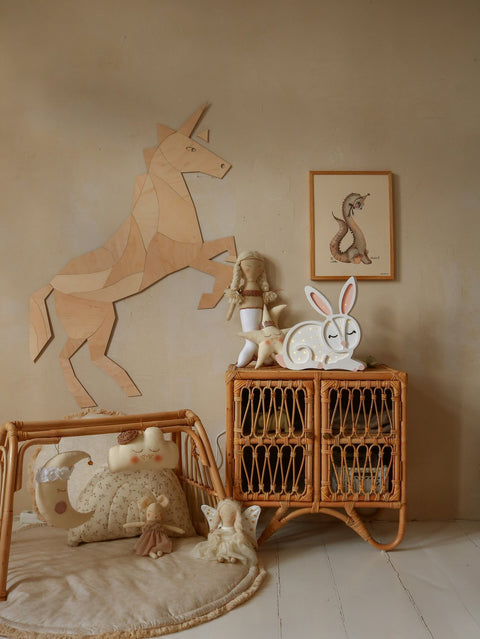 1. Origami-style wooden unicorn wall decoration in a child's room with rattan furniture and plush toys