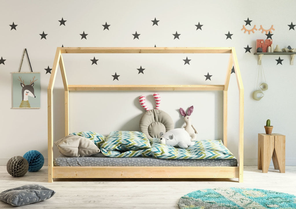 1. Kocot Kids Bella house bed in natural wood with colorful bedding and plush toys in a star-themed children's room