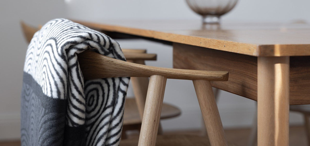 2. Labbvenn gray and white patterned pet blanket elegantly placed on a wooden chair beside a dining table in a contemporary room