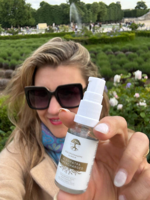 1. Woman holding HOIA homespa Hyaluronic Acid Elixir Kleopatra SUPERCHARGED in a garden setting