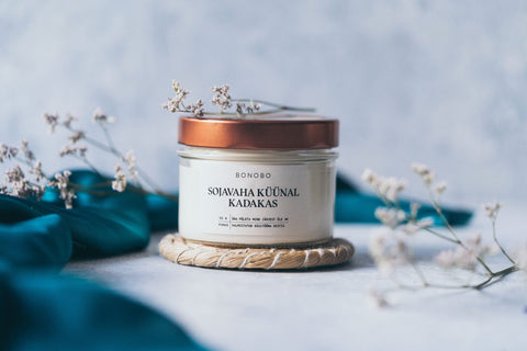 2. BONOBO juniper candle with copper lid on textured surface with teal fabric and dried flowers