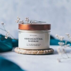 3. Close-up of BONOBO juniper candle with copper lid on textured surface with teal fabric