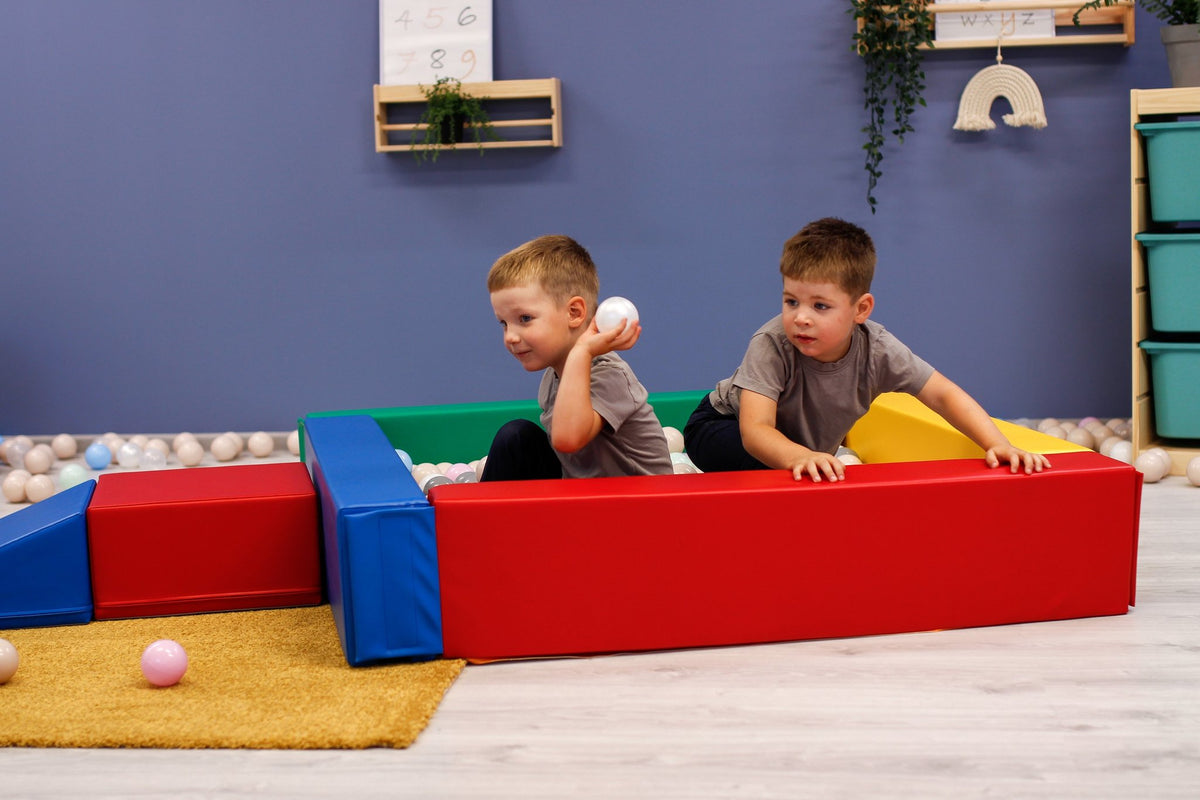 9. Two children playing with balls in a disassembled multicolor IGLU soft play ball pit