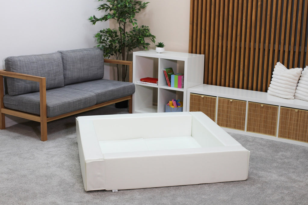 4. White IGLU soft play ball pit in a modern living room with grey sofa and wooden shelves