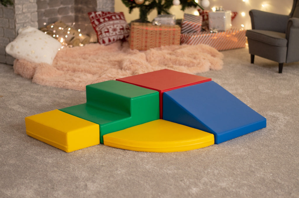 7. Multi-color foam block set arranged in a corner climber configuration in a cozy indoor setting with holiday decor
