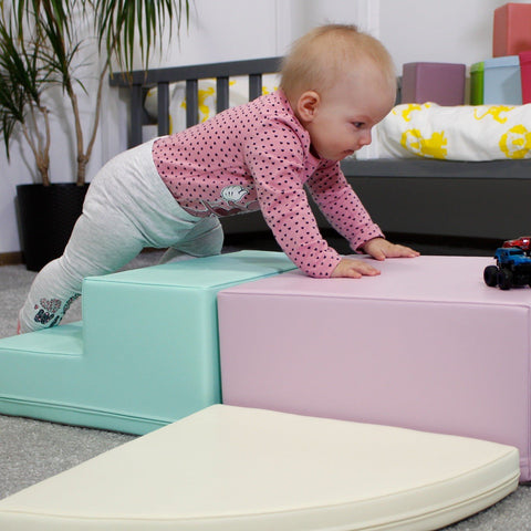 5. Baby crawling on IGLU pastel foam blocks in a nursery, developing motor skills and strength