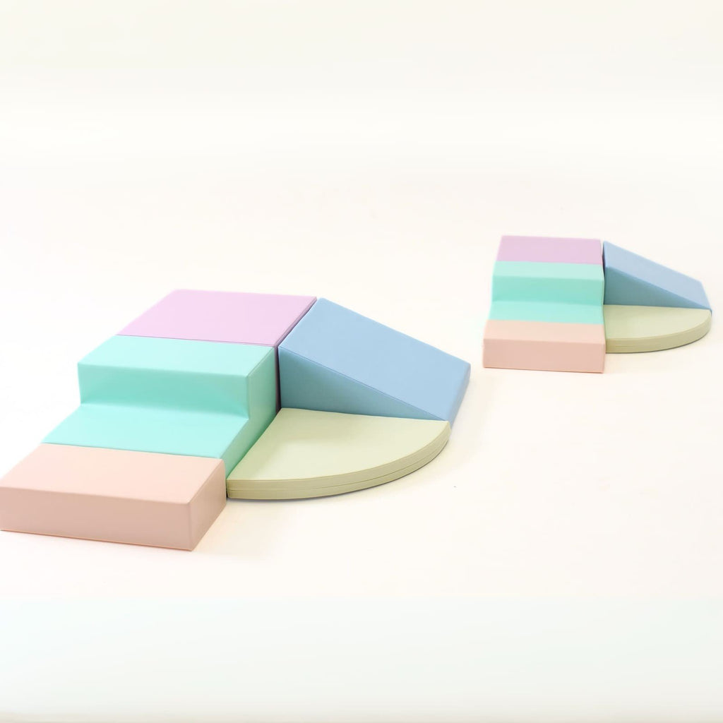 7. Two sets of IGLU pastel foam blocks arranged in a corner climber setup on a white background
