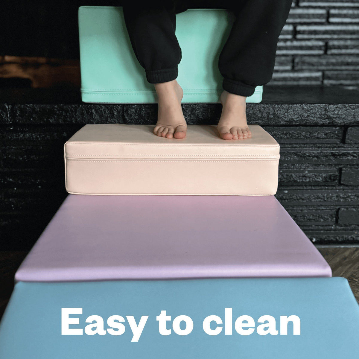 6. Close-up of feet on IGLU pastel foam blocks with text 'Easy to clean' highlighting maintenance