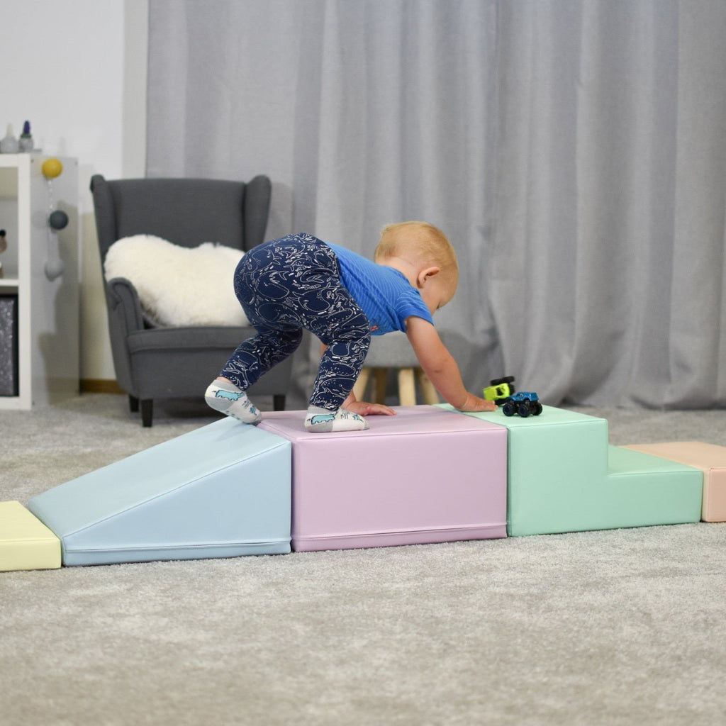 24. Child climbing on IGLU pastel foam blocks in a living room, enhancing physical activity and coordination