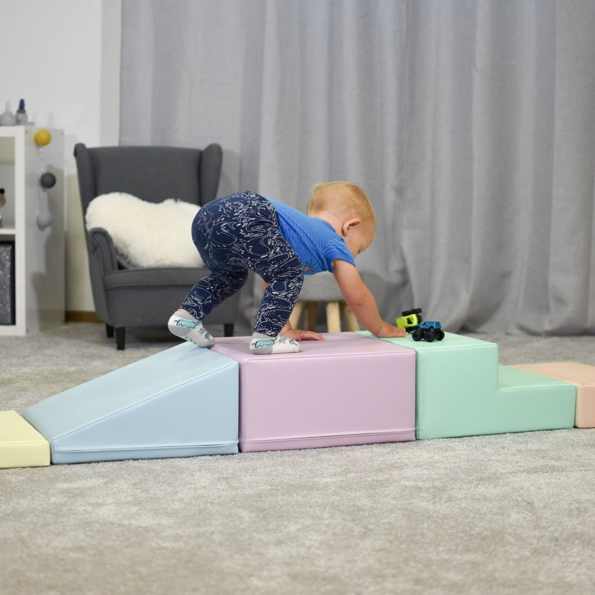 24. Child climbing on IGLU pastel foam blocks in a living room, enhancing physical activity and coordination