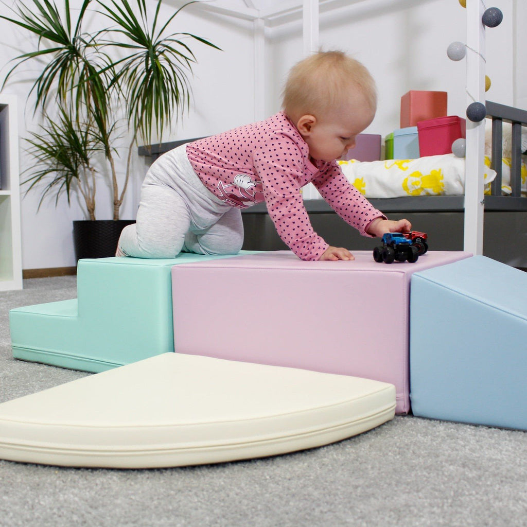 2. Child playing on IGLU pastel foam blocks in a nursery setting, promoting motor skills and creativity