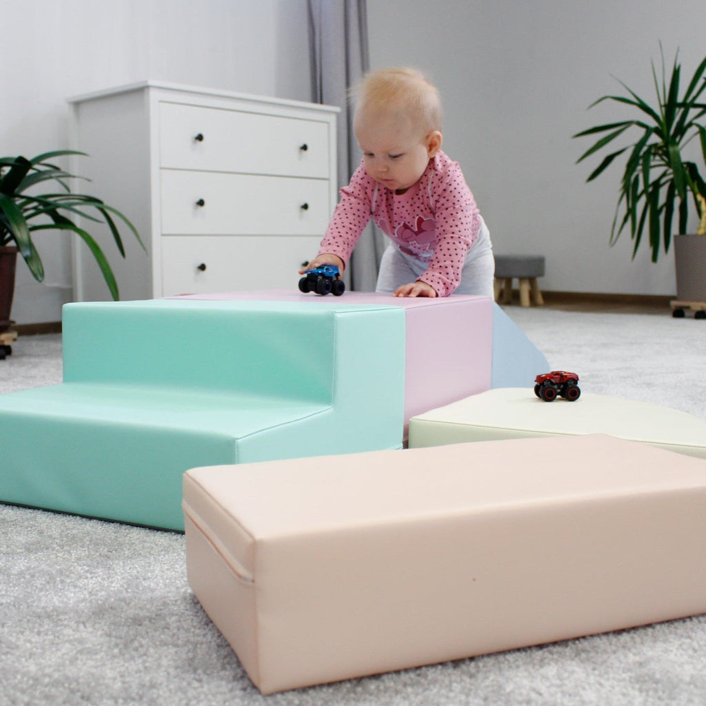 18. Child climbing on IGLU pastel foam blocks in a nursery, promoting physical activity and social interaction