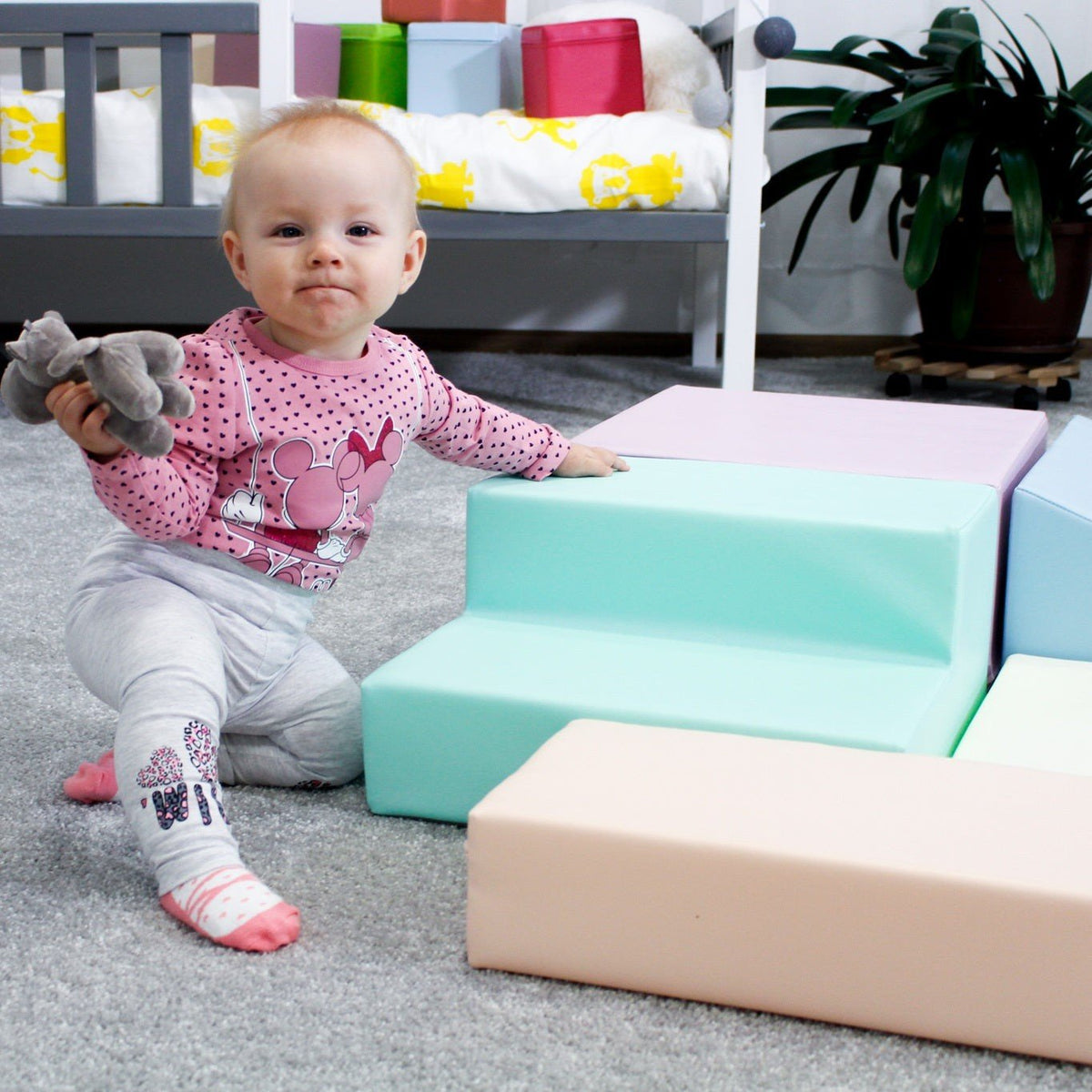 21. Baby sitting on IGLU pastel foam blocks, encouraging sensory play and motor skill development