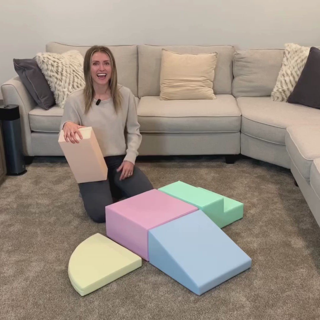 20. Woman demonstrating IGLU pastel foam block set in a living room, highlighting versatility and design
