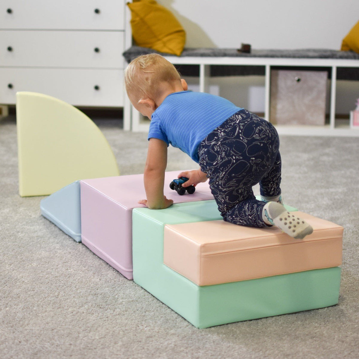 19. Toddler exploring IGLU pastel foam blocks in a playroom, developing balance and coordination