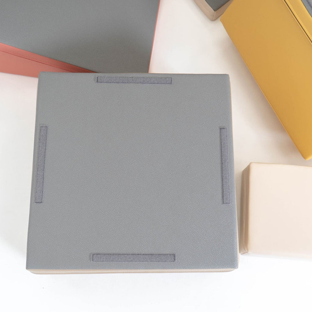 3. Close-up of grey foam block with non-skid bottom and beige and yellow blocks in background