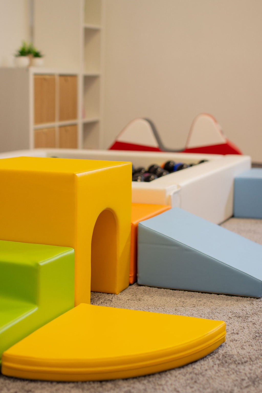 10. Close-up of IGLU foam blocks in light multicolor next to a ball pit in a playroom