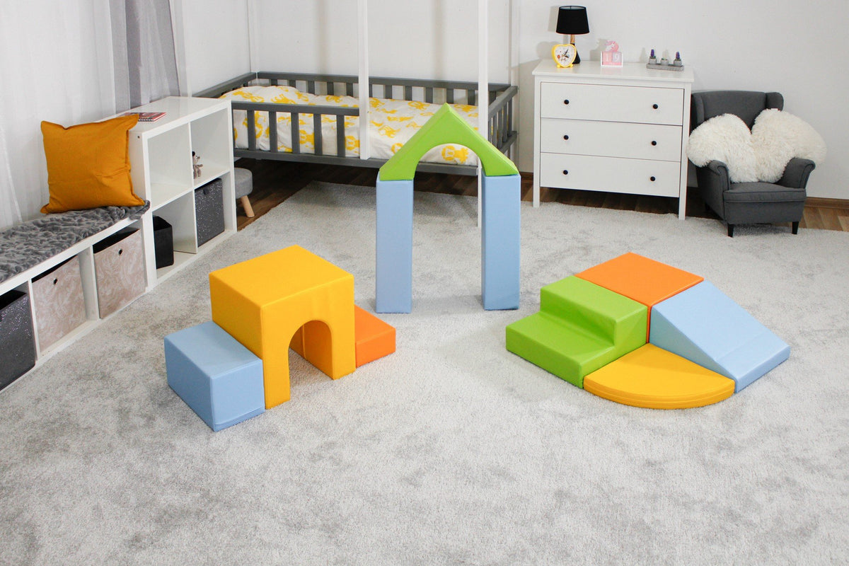 11. IGLU foam block set in light multicolor arranged in a child's bedroom with grey carpet and white furniture