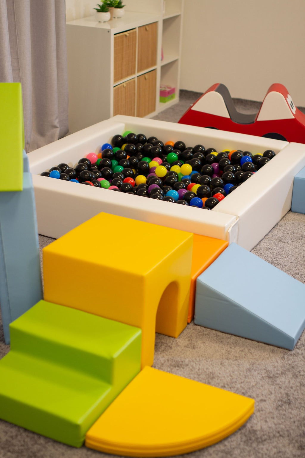 7. Close-up of IGLU foam blocks in light multicolor next to a ball pit in a playroom