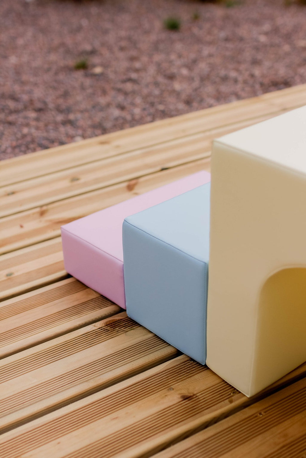 3. Close-up of pink, blue, and yellow foam blocks on wooden surface, highlighting texture and color