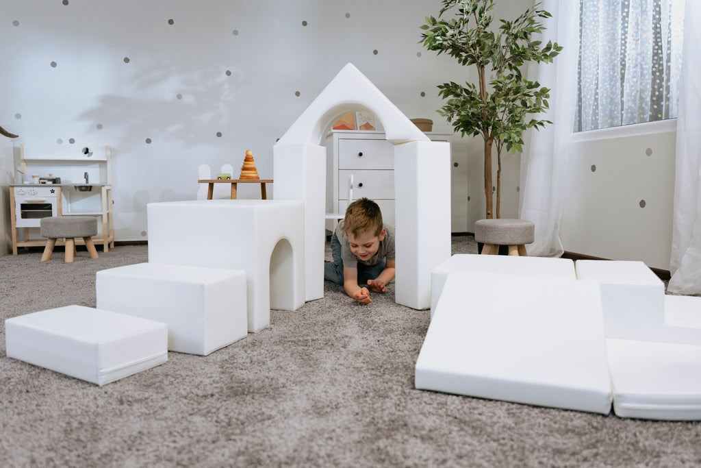 1. Child crawling through white foam block tunnel in a playroom, part of IGLU Adventurer set