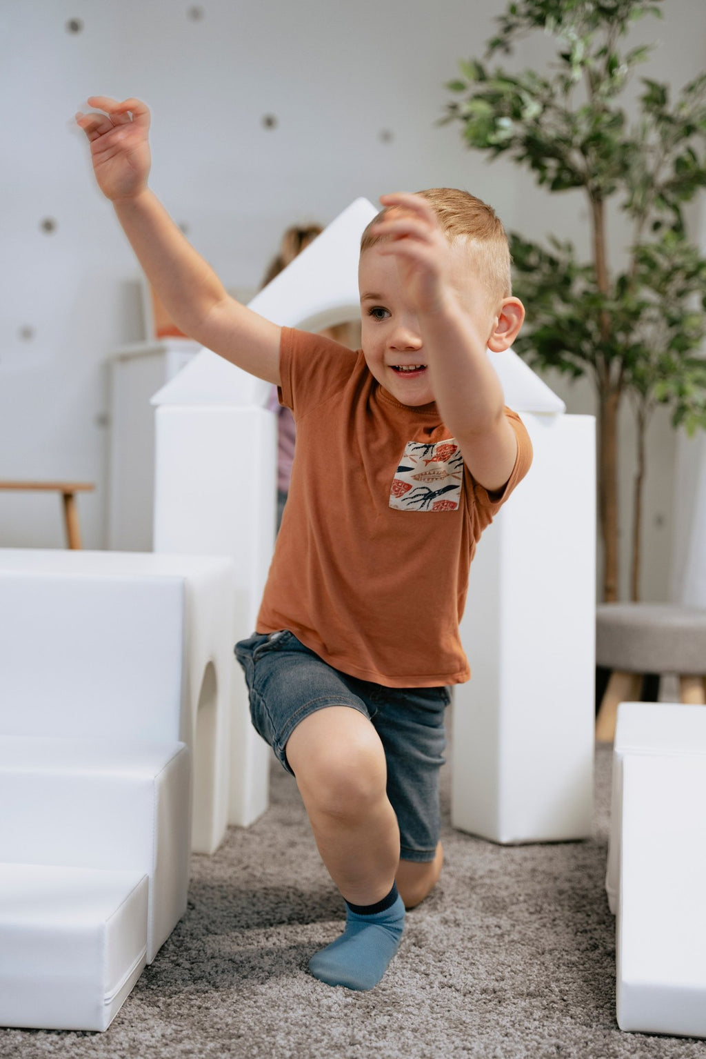 1. Child running through white foam block setup in a playroom, part of IGLU Adventurer set