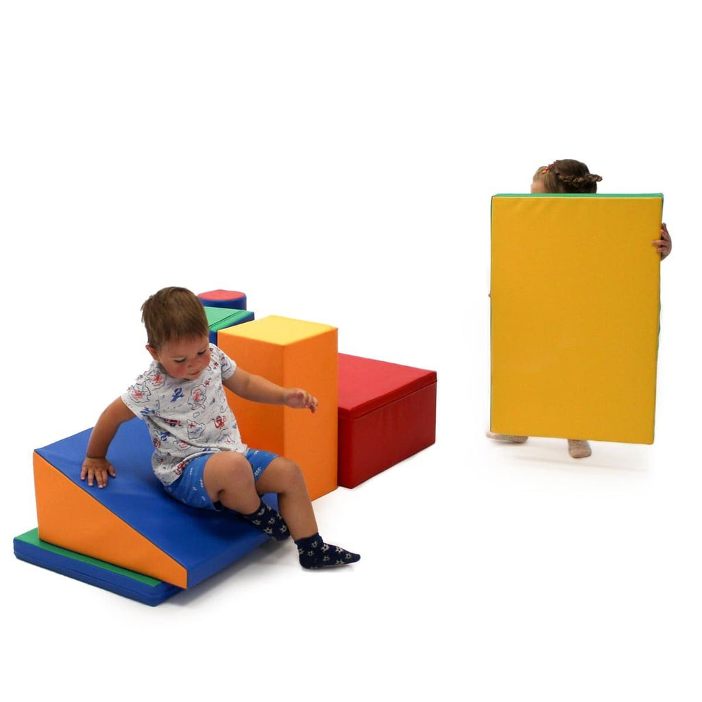 1. Two children interacting with multicolor foam blocks in a playroom