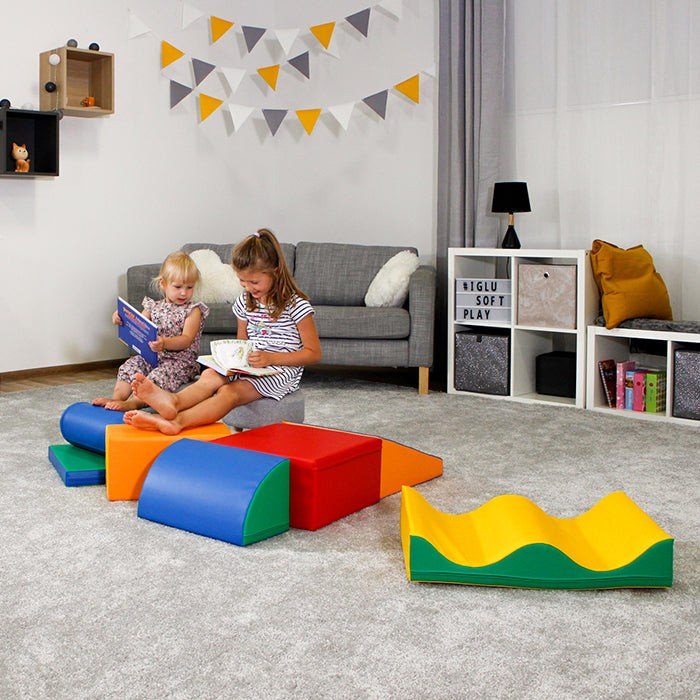 1. Two children reading on multicolor foam blocks in a playroom