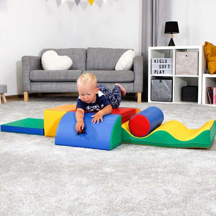 1. Child playing on multicolor foam blocks in a playroom setting