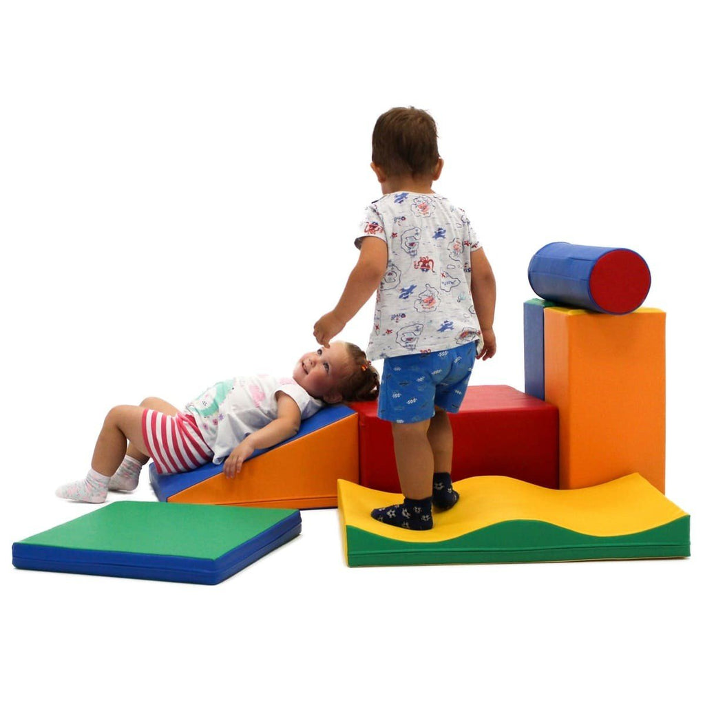 1. Two children playing on multicolor foam blocks in a playroom setting