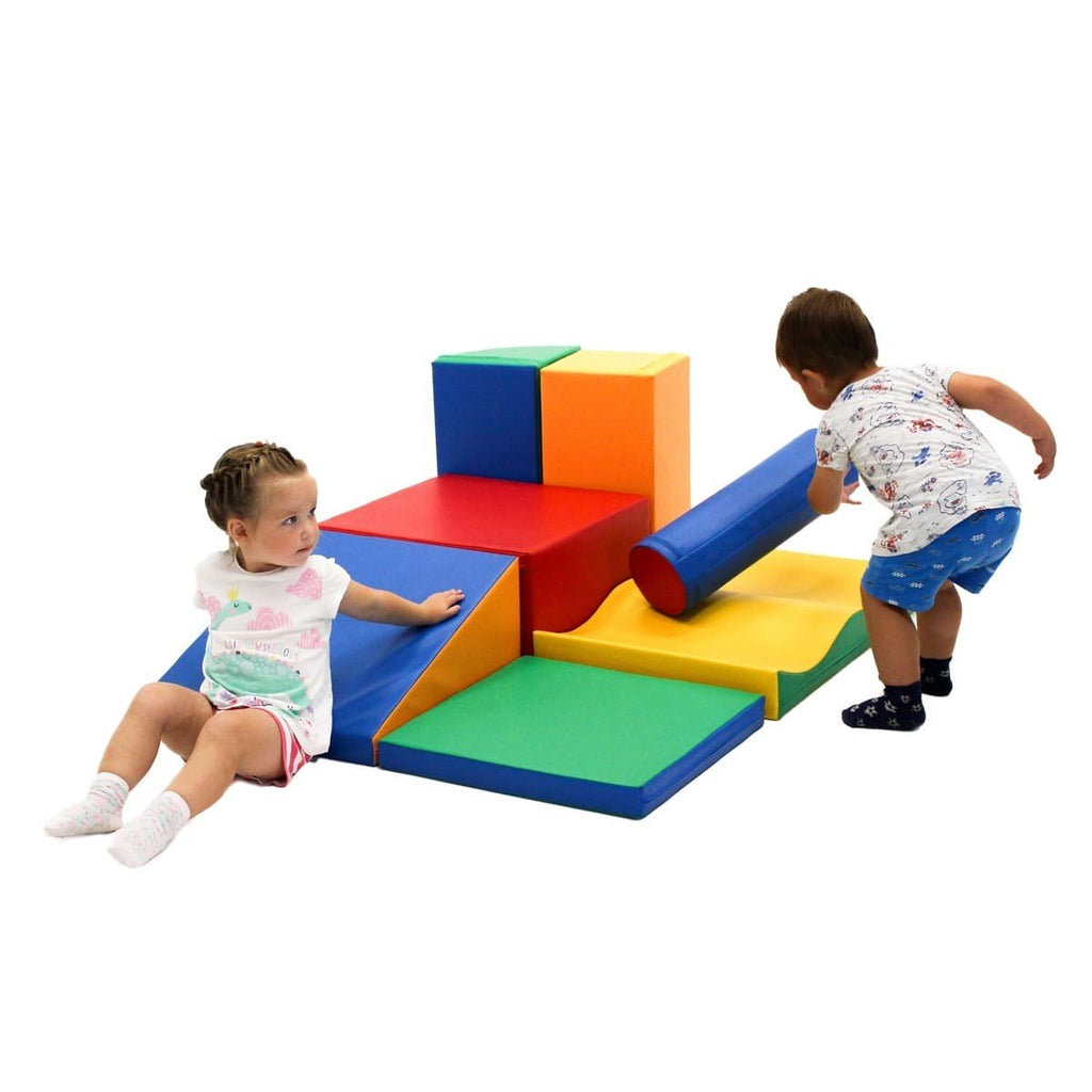 1. Two children interacting with multicolor foam blocks in a playroom