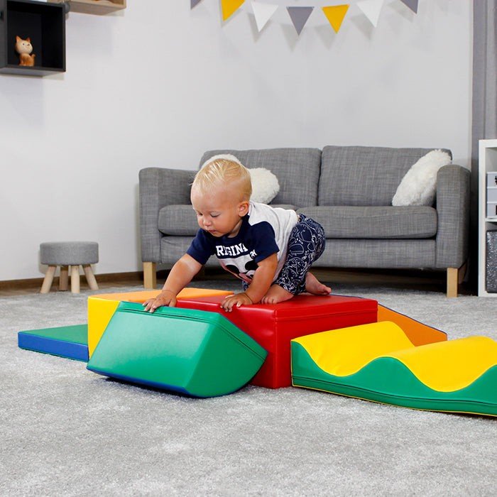 1. Child climbing on multicolor foam blocks in a playroom setting