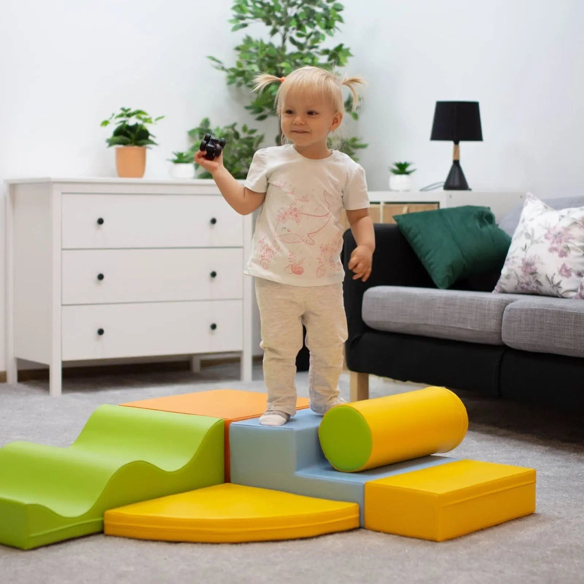 1. Child standing on IGLU Explorer foam block set in light multicolor in a living room