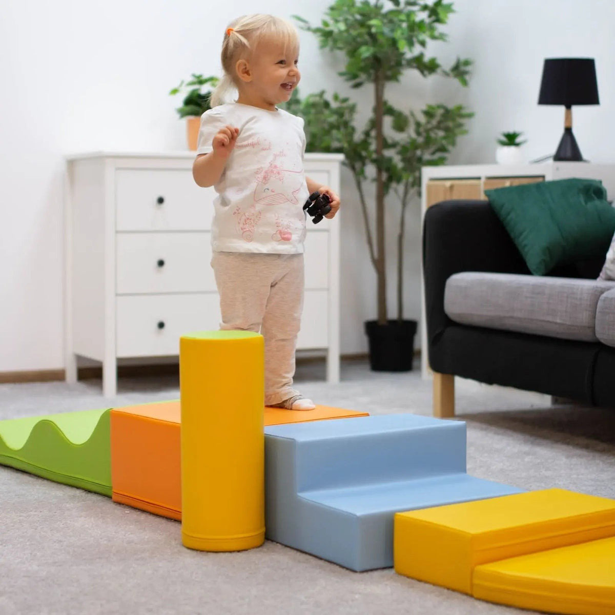 1. Toddler playing on IGLU Explorer foam block set in living room, featuring light multicolor blocks