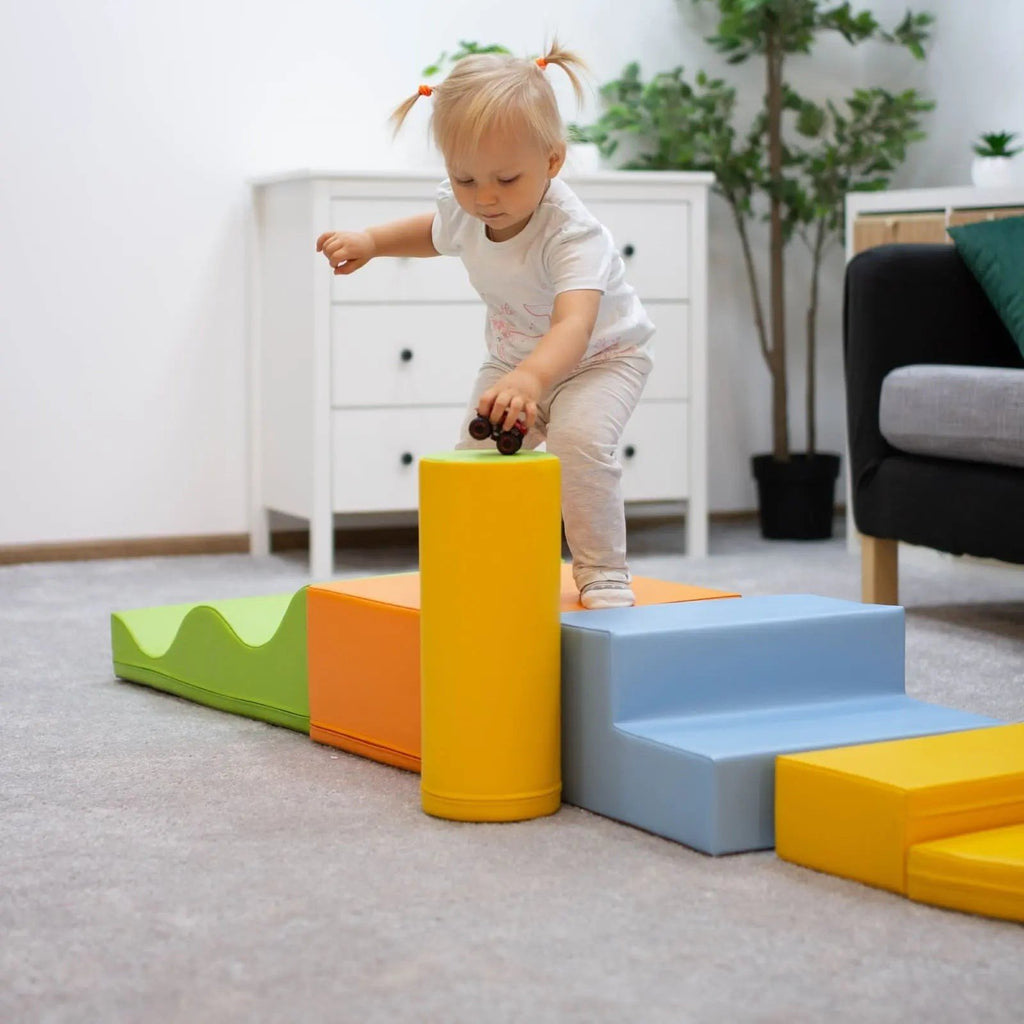 1. Toddler balancing on IGLU Explorer foam block set in light multicolor in a living room