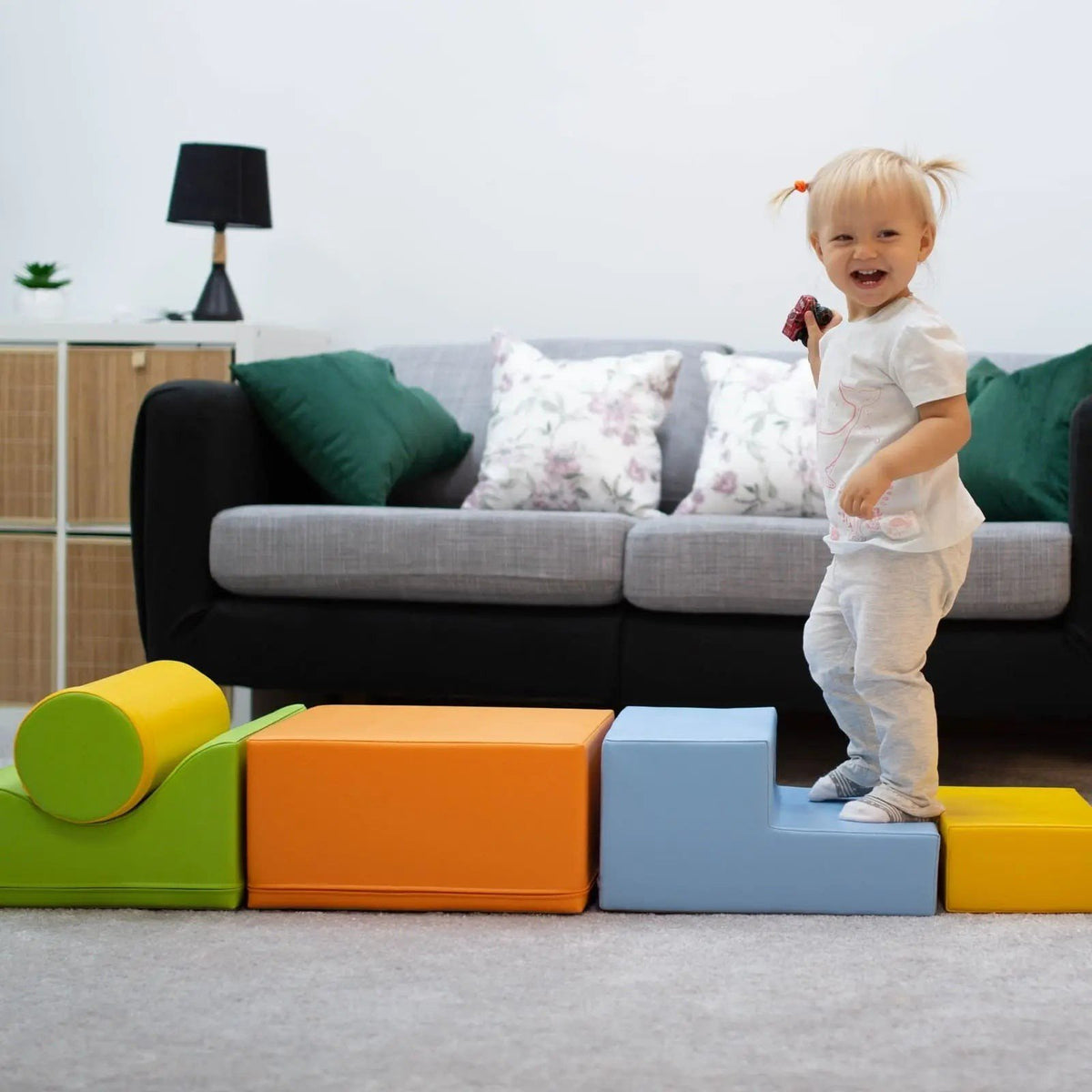 1. Child standing on IGLU Explorer foam block set in light multicolor in a living room