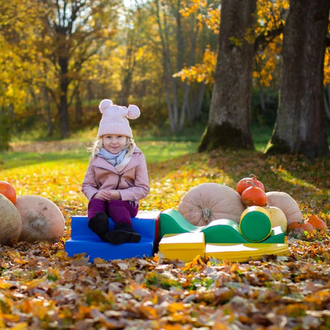 1. Girl sitting on multicolor foam blocks in autumn forest setting