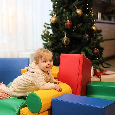 1. Baby playing with multicolor foam blocks near Christmas tree