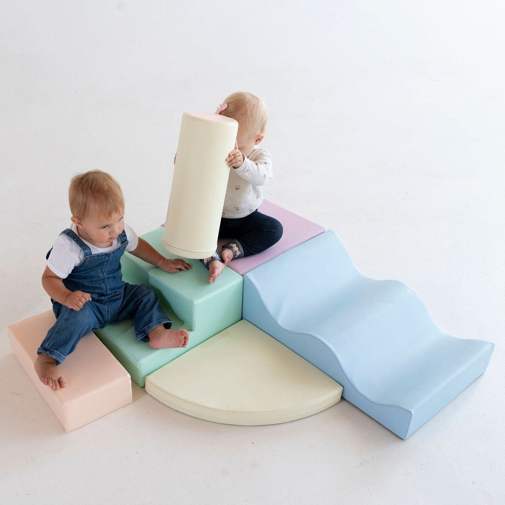 1. Two toddlers playing on pastel foam blocks in a studio