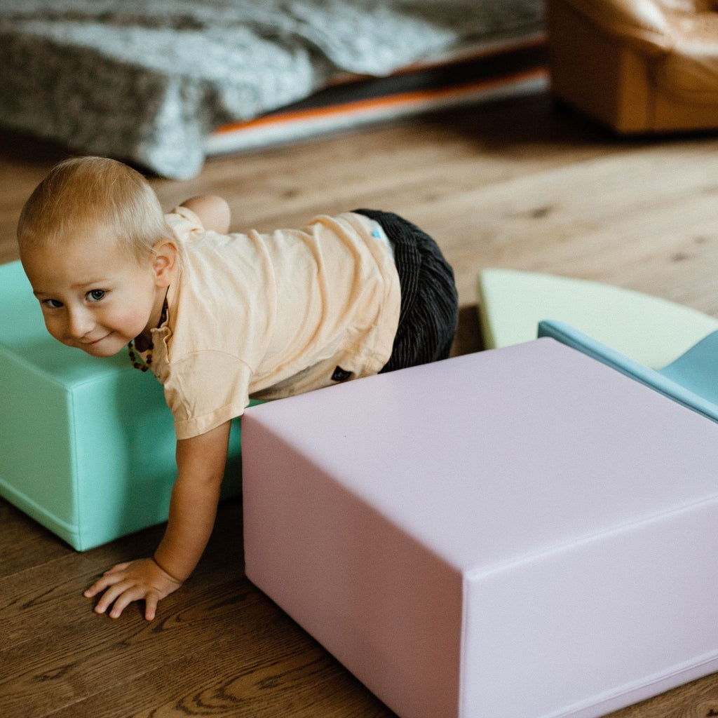 1. Toddler crawling through pastel foam blocks