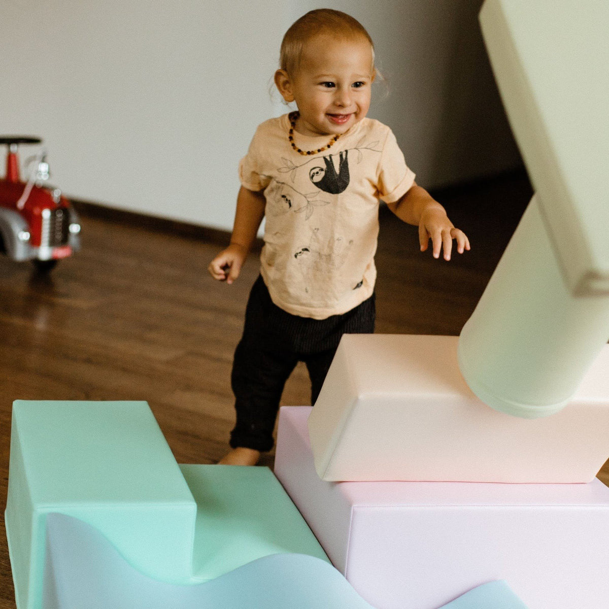 1. Smiling toddler standing among pastel foam blocks