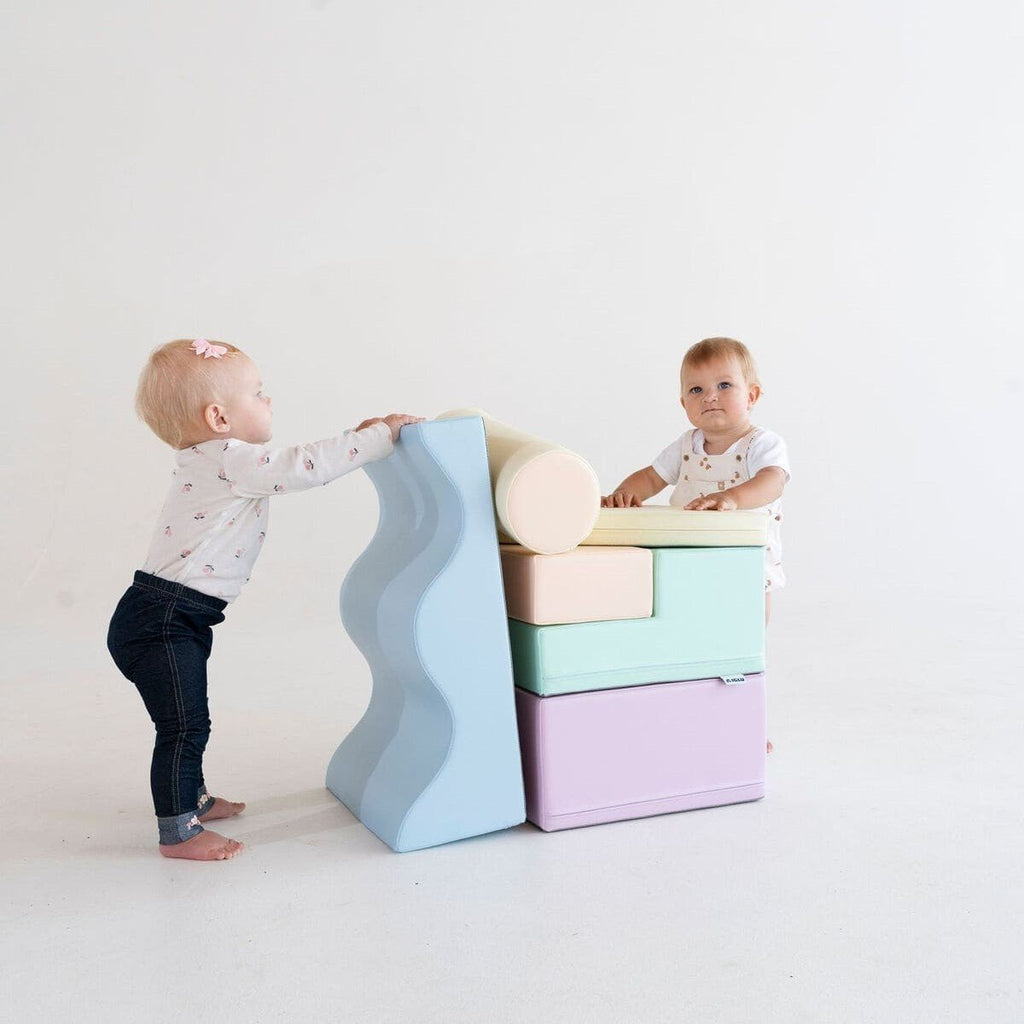 1. Two toddlers playing with pastel foam blocks in a studio