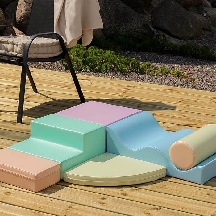 2. Pastel foam blocks arranged on a wooden deck outdoors