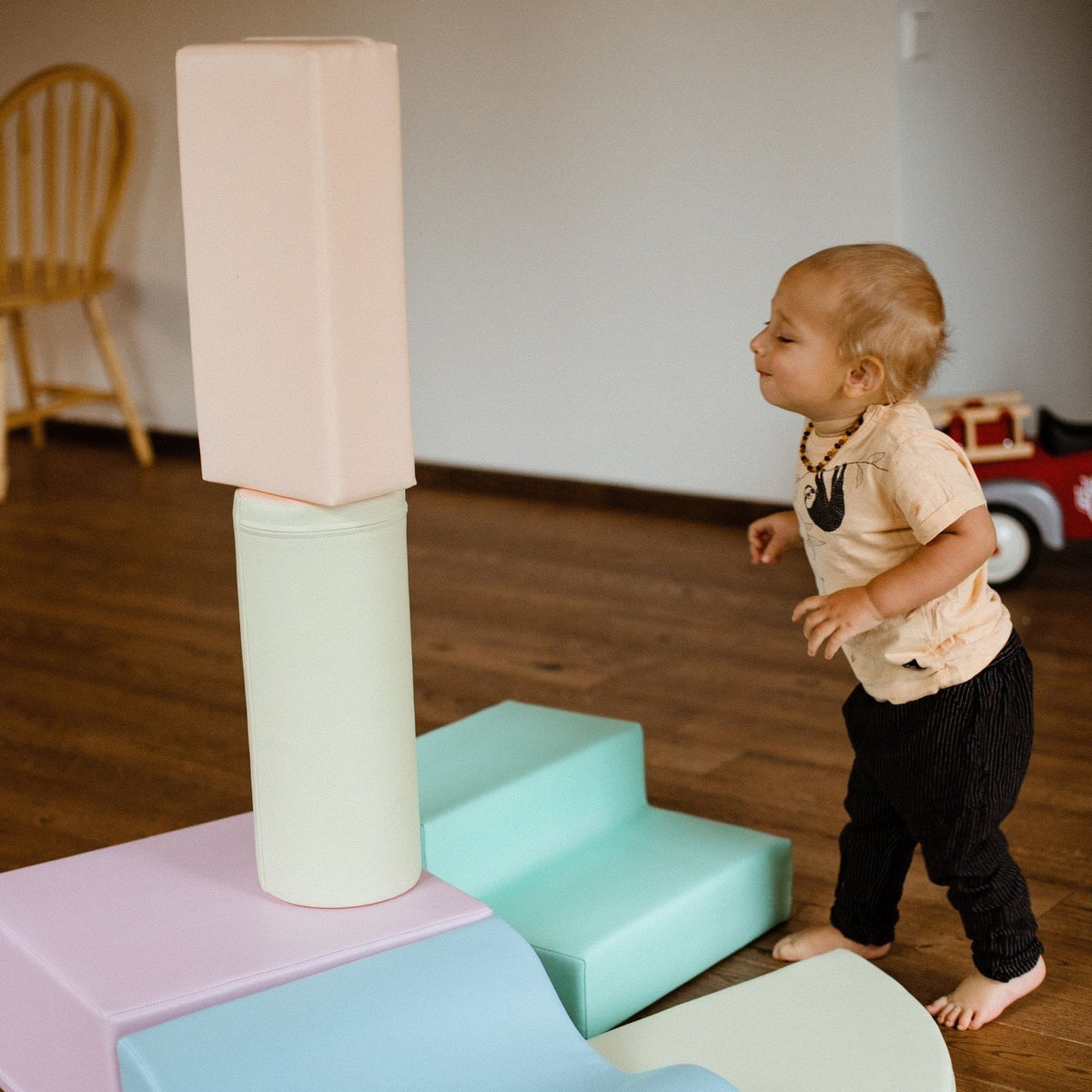 1. Child playing with stacked pastel foam blocks